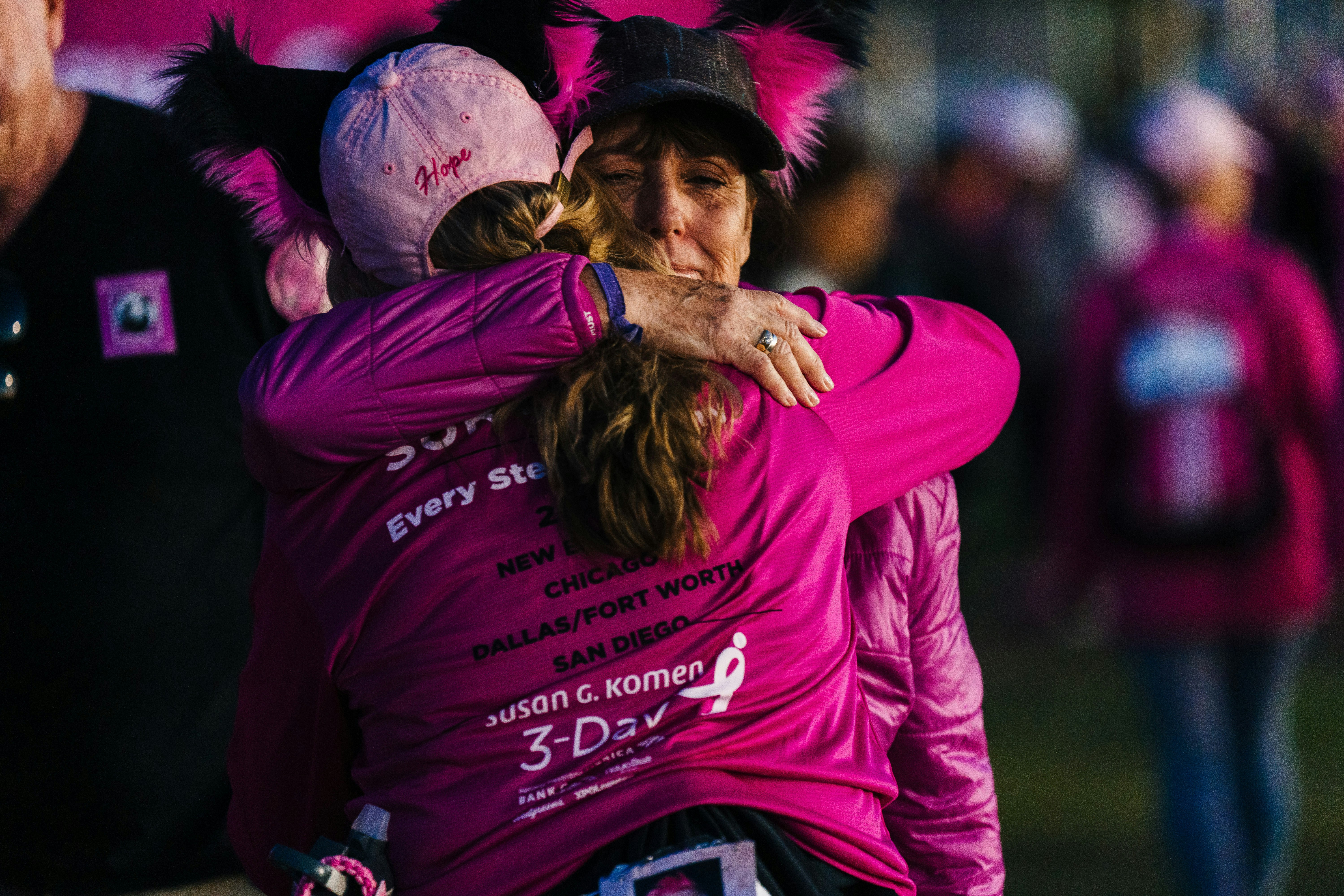 Dos mujeres se abrazan tras una marcha solidaria por el cáncer de mama