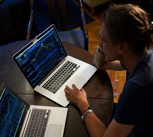 analisis datos Una persona está analizando datos en dos ordenadores