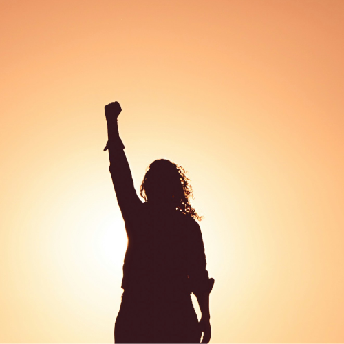 Cabecera blog emociones Una mujer eleva el puño al cielo en señal de ánimo