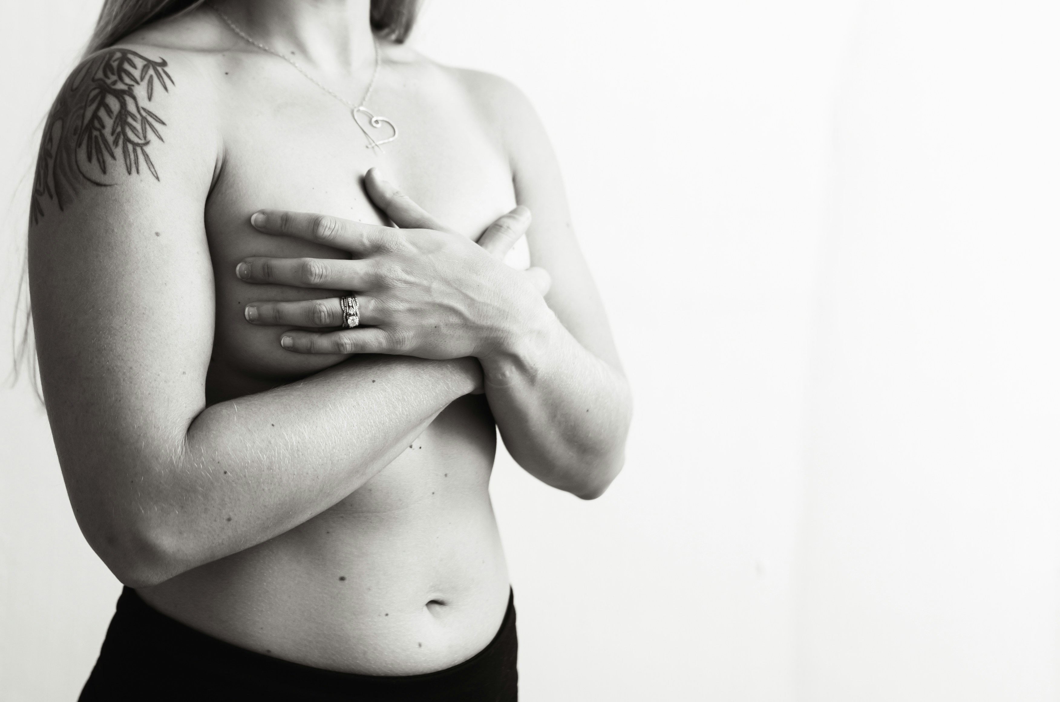 Una mujer con cáncer de mama esconde sus pechos detrás de las manos