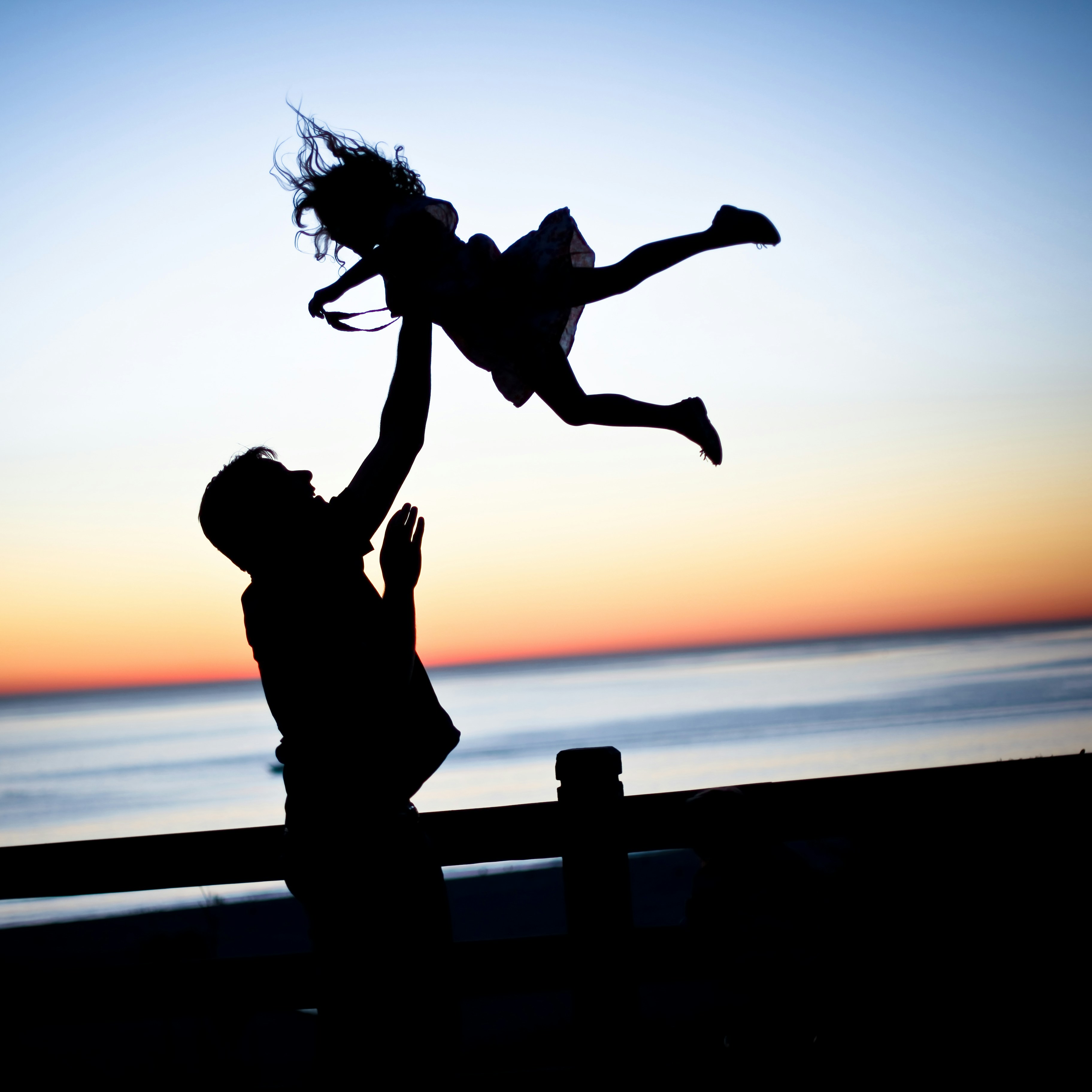 Un padre juega en la plaza con su hija
