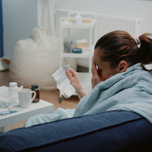 efectos secundarios Una mujer muestra malestar mientras mira un proespecto de medicamento