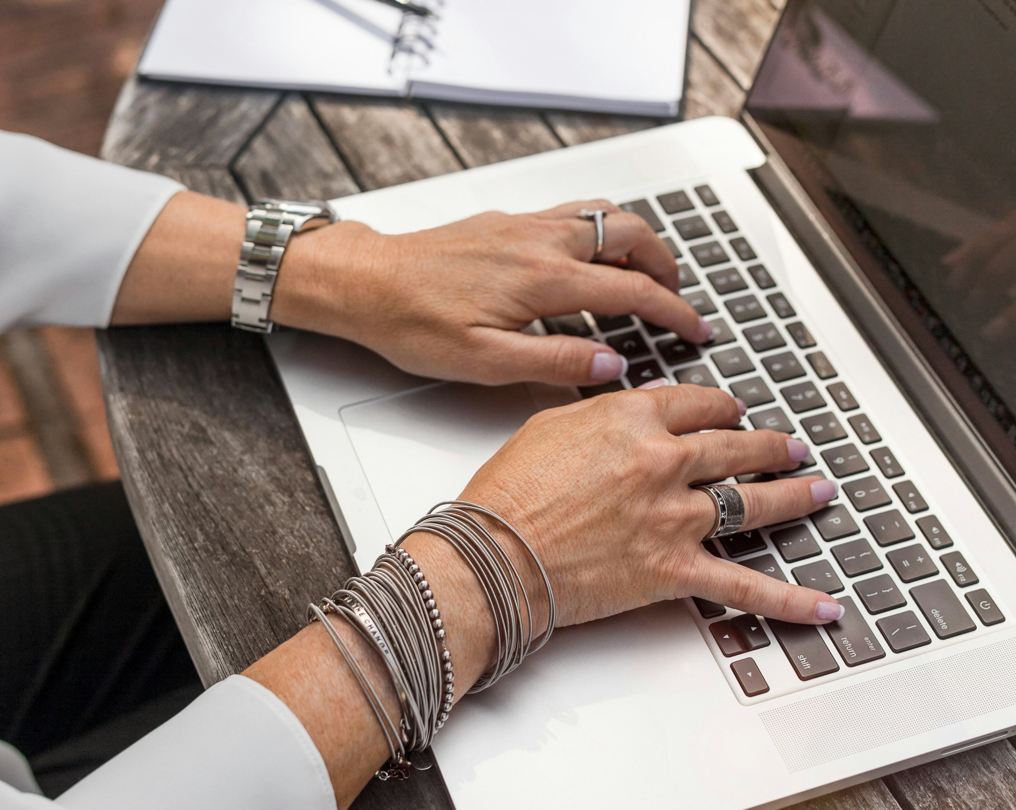 Una mujer escribe en el teclado de un portátil mientras trabaja